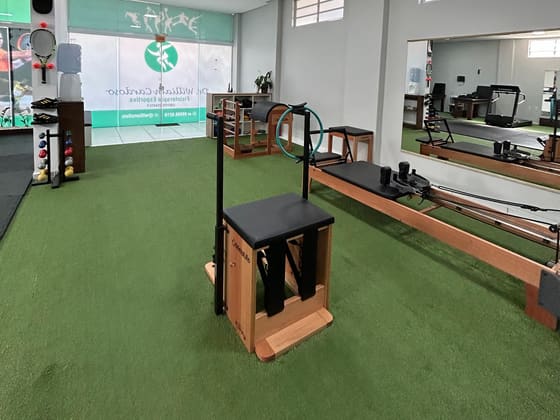 Aparelhos de pilates na clínica, sobre grama sintética.